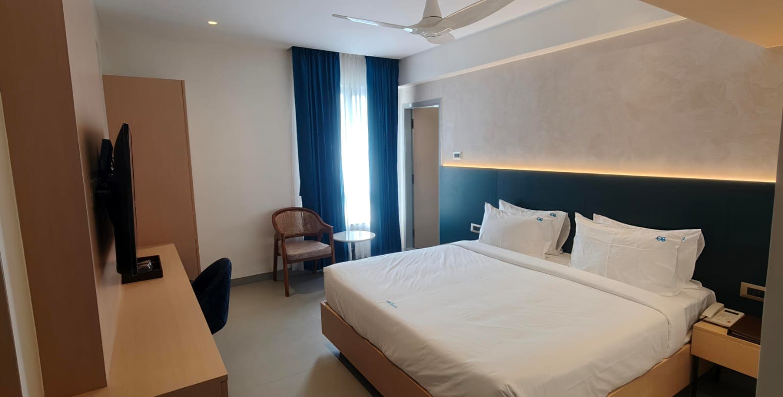 Room with balcony and sea-facing glass door at Hotel Ocean Blue Vizag