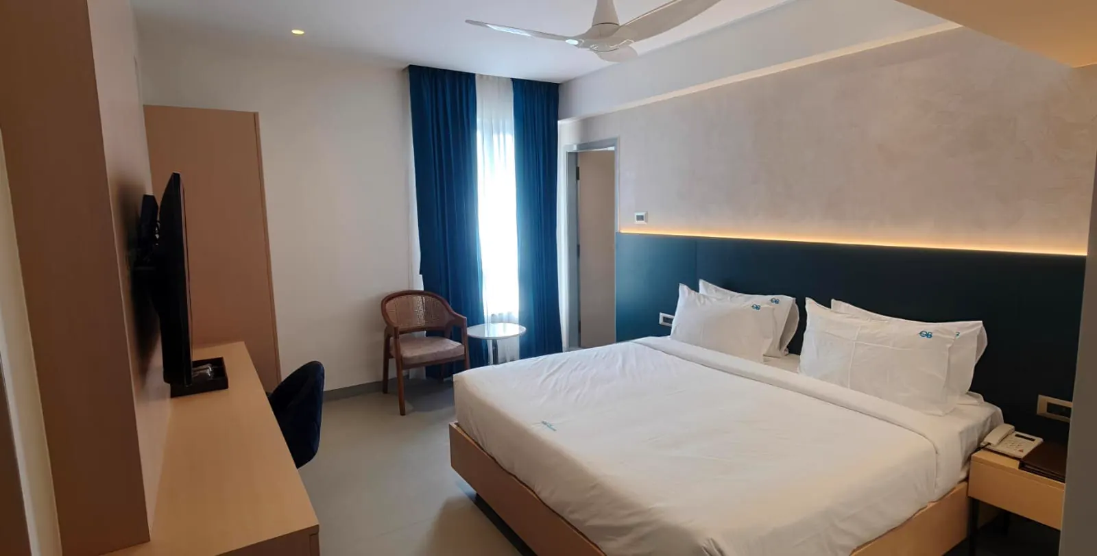 Room with balcony and sea-facing glass door at Hotel Ocean Blue Vizag